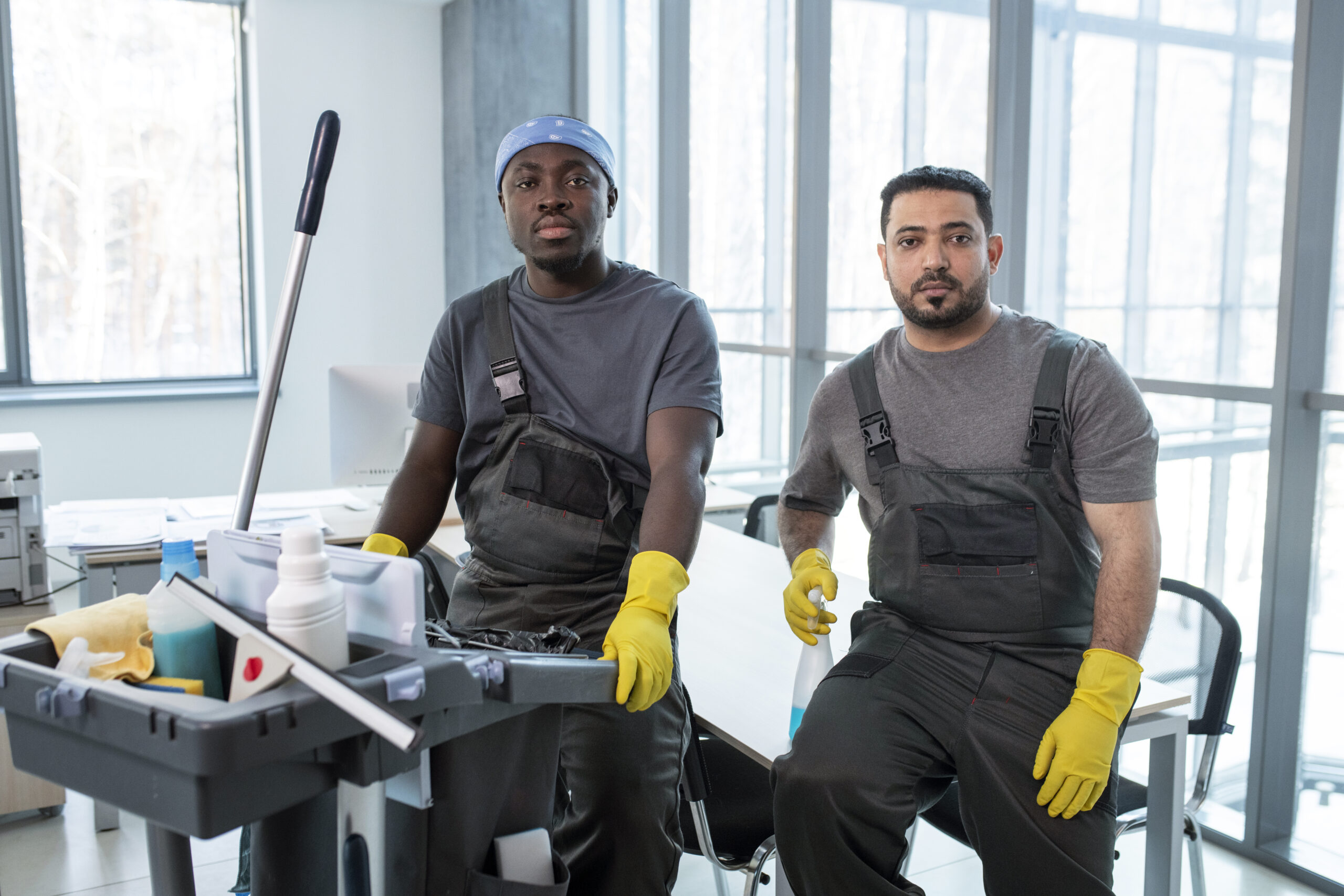 medium shot workers with cleaning cart scaled